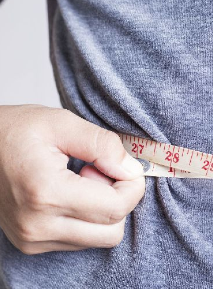 Persona midiéndose la cintura