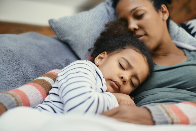 Mujer toma siesta con su hija