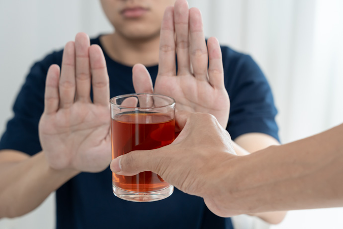 Hombre rechazando copa porque sabe cuánto tarda el cuerpo en eliminar el alcohol.