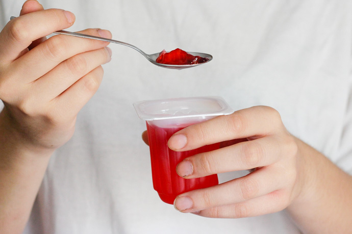 Mujer come gelatina por dieta blanda