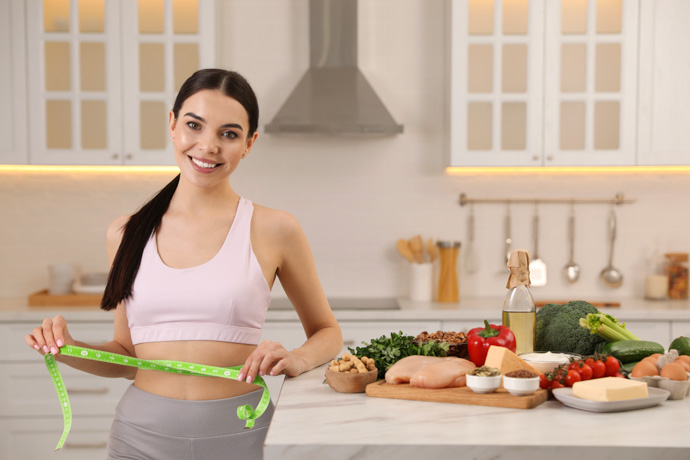 Mujer que realiza la dieta keto midiéndose la cintura.