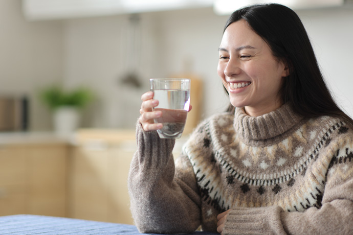 Mujer toma agua para hidratarse
