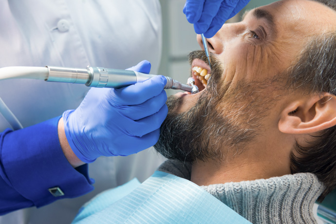 Hombre tratándose en el dentista las manchas marrones en los dientes.