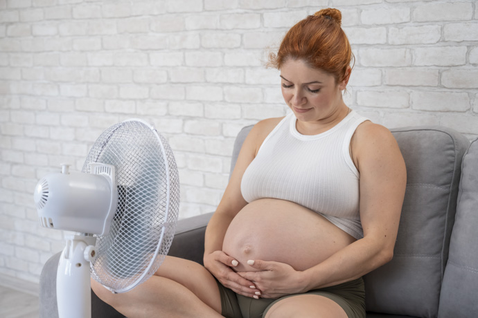 Mujer embarazada utiliza ventilador