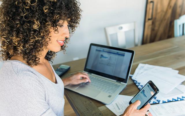Mujer frente a computadora revisando sus finanzas