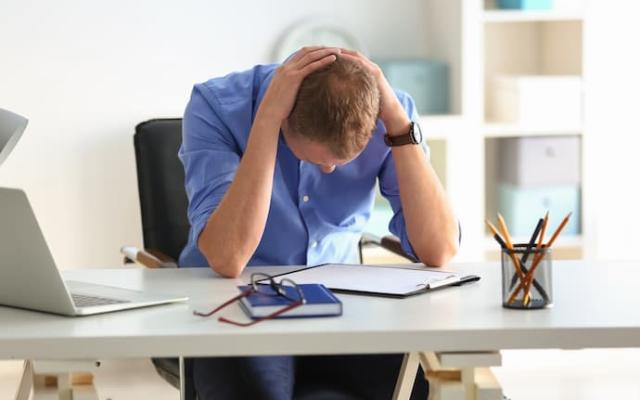 hombre con mala salud mental en el trabajo