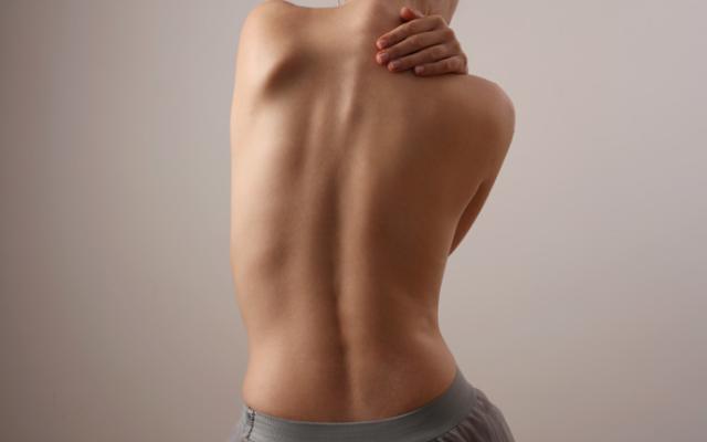 Persona mostrando cómo corregir la postura de la espalda.