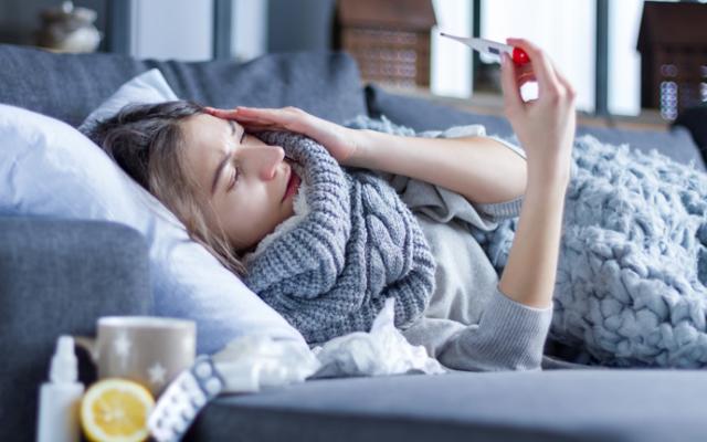 Mujer enferma que se pregunta cómo prevenir la gripe. 
