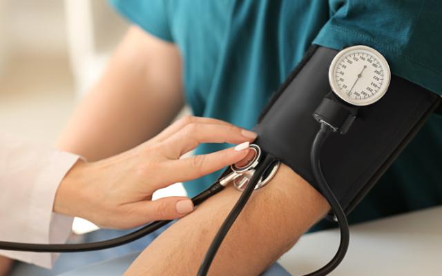 médico midiendo presión sanguínea