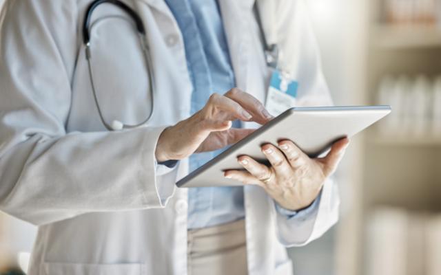 Médico sigue historial clínico de paciente en tableta