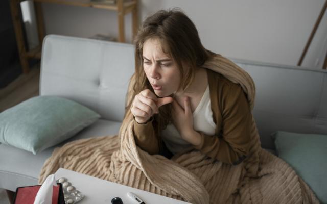 Mujer con resfriado tosiendo