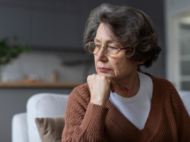 Mujer mayor reflexionando sobre cómo prevenir el Alzheimer.