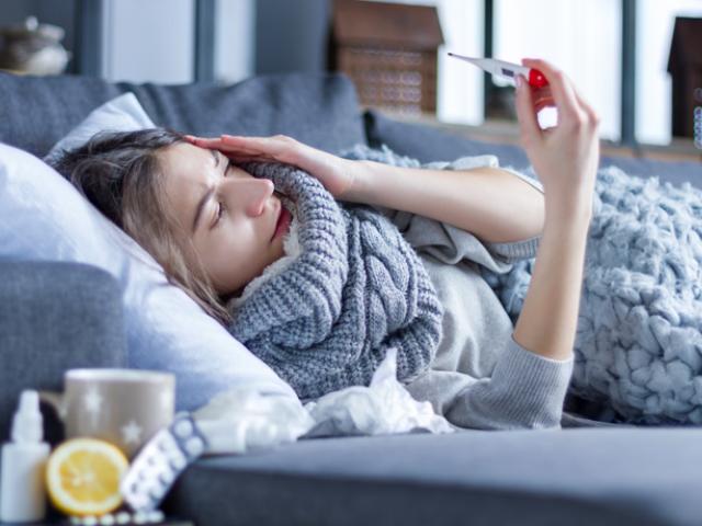 Mujer enferma que se pregunta cómo prevenir la gripe. 