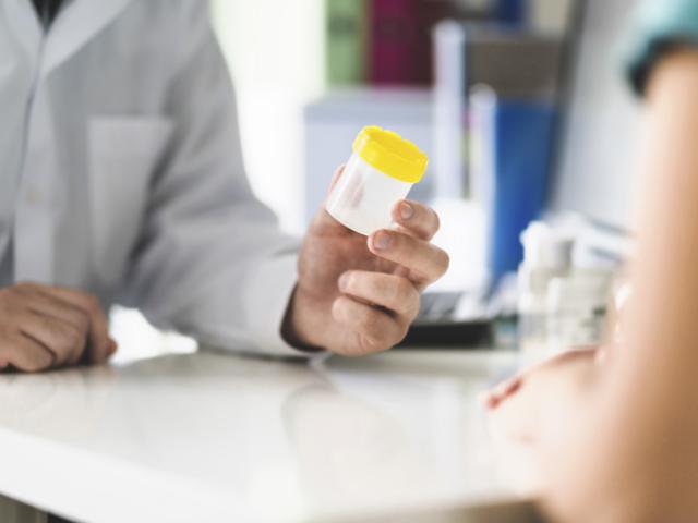 Doctor habla con paciente sobre prueba de orina