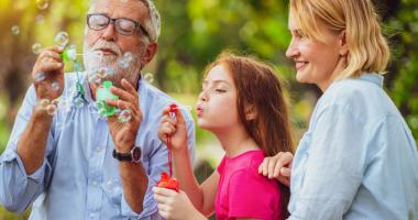 Familia jugando con burbujas en el parque